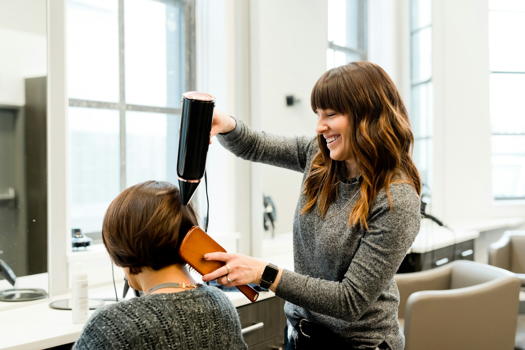 Profissional cuidando do cabelo de uma cliente em um salão de beleza